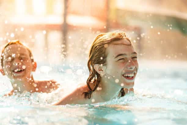 La'bel Balagne: due ragazzi ridono mentre nuotano in piscina in una giornata calda.
