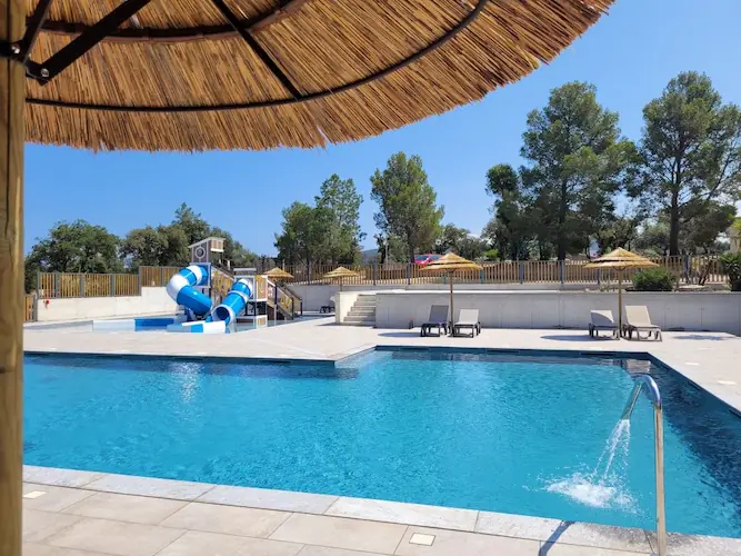 Entspannungsbereich mit Sonnenschirmen am Pool auf dem Campingplatz auf Korsika